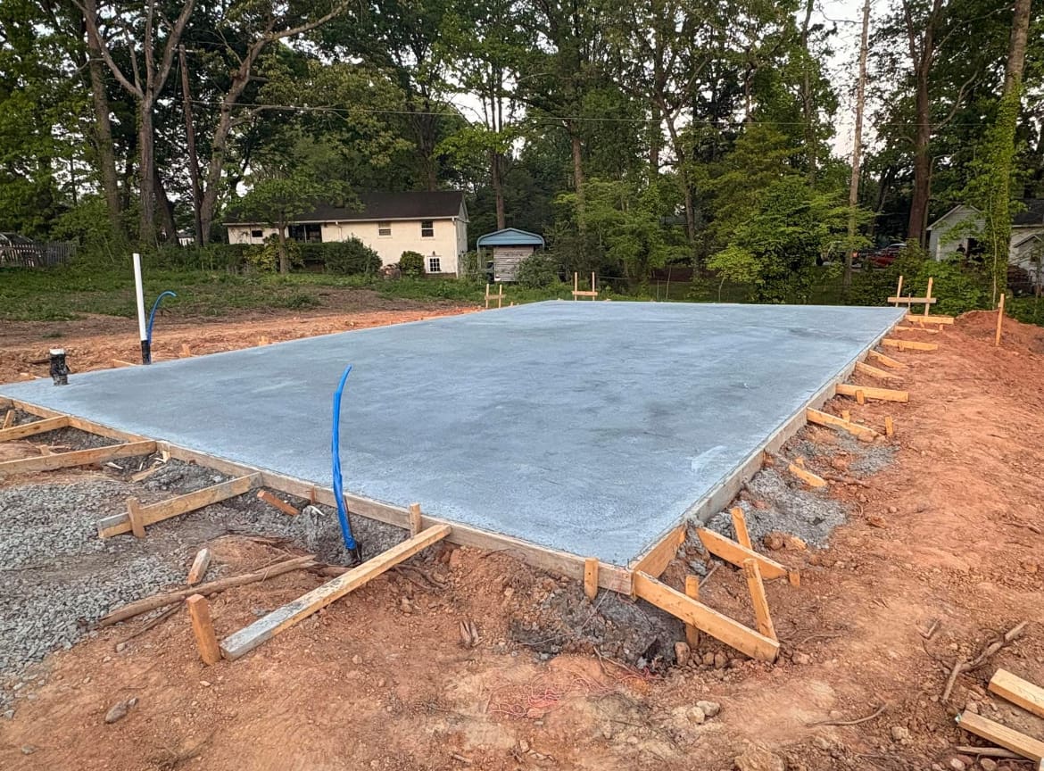 Finished Concrete Foundations job in Denver, North Carolina by Local Concrete Co — clean control-joint pattern, smooth troweled surface, full property protection during pour.